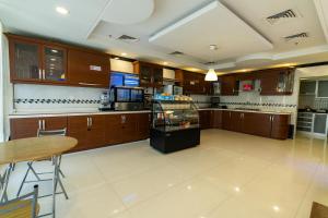 شقق نيروز ان للشقق المخدومة - Newroz N Serviced Apartments في الرياض: مطبخ كبير مع دواليب خشبية وطاولة