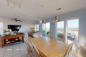 a dining room with a wooden table and chairs at System Shutdown in Kure Beach