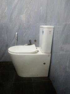 a white toilet in a bathroom with a sink at Sunrise City Palace in Negombo
