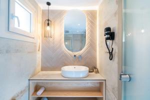 a bathroom with a sink and a mirror at ILIORAMA LUXURY SUITES in Skala Potamias