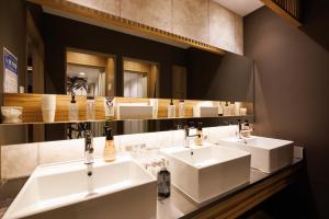 a bathroom with two sinks and a large mirror at HOTEL Cargo Shinsaibashi in Osaka