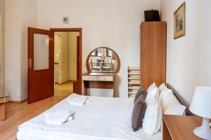 1 dormitorio con cama blanca y espejo en PM Services Flora Apartments, en Borovets