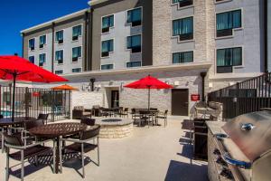 a patio with tables and umbrellas in front of a building at TownePlace Suites by Marriott Waco South in Waco