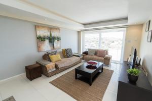 uma sala de estar com um sofá e uma mesa em The Pearls 4th Floor Luxury Apartment with inverter em Summerstrand