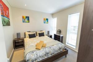 a bedroom with a large bed and a window at The Pearls 4th Floor Luxury Apartment with inverter in Summerstrand