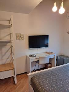 a bedroom with a desk with a television and a bed at VILLA ROOMS in Laives +19 photos