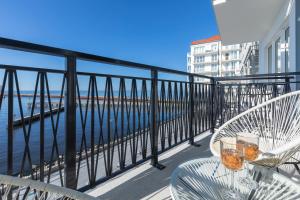 ダルウフコにあるBulwar Zachodzącego Słońca Apartment with Sea View Darłowo by Rentersのテーブルと椅子、水辺を見渡すバルコニー