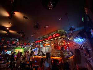 a group of people sitting at a bar in a restaurant at Da Nang S Phuot Hostel in Da Nang