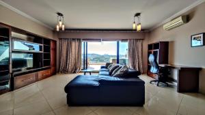 een woonkamer met een blauwe bank en een groot raam bij Magic Seaview Deluxe 3BR with Hot Tub in Sliema