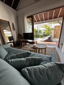 Deluxe 1 Sula villa in uluwatu في أُلُواتو: غرفة معيشة مع أريكة وطاولة