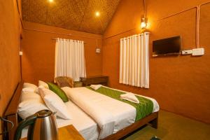 KanthalloorにあるFOOD FOREST KANTHALLOORのベッドルーム(ベッド1台、テレビ付)