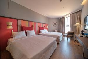 a hotel room with two beds and a desk at Apec Mandala Chambay Mũi Né in Ấp Thiẹn Ái +6 photos