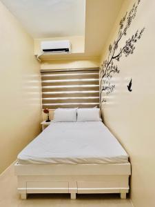 a bedroom with a white bed with a wall at * * L Iloilo's Quirky Oasis in Iloilo City