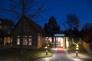 a building with a sign that reads kroger at night at Hotel Restaurant Zur Linde in Westerstede