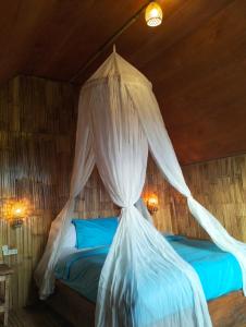 a bedroom with a bed with a mosquito net at Wanagiri sunset glamping in Gitgit