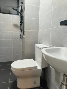 łazienka z toaletą i umywalką w obiekcie Meritus Service Apartment w mieście Perai
