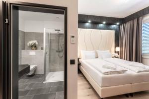 een slaapkamer met een groot bed en een douche bij PLAZA INN Wiener Neustadt, BW Signature Collection in Wiener Neustadt