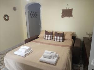 ein Schlafzimmer mit einem Bett mit Handtüchern darauf in der Unterkunft Dimora San Giorgio con parcheggio auto privato in Gravina in Puglia