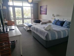 a bedroom with a bed and a desk and a room with a bed at Brookes Hill Studio, Unit 156 in Port Elizabeth