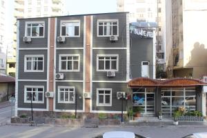 un edificio en una calle de la ciudad con una tienda en Asus Palmiye Otel, en Adana