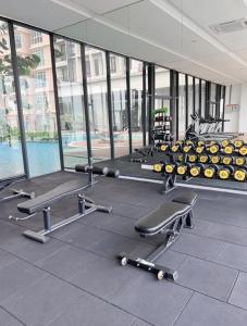 a gym with a row of exercise equipment and a large window at Kenwingston Skyloft Apartment Doorsteps to BRT Subang USJ in Subang Jaya