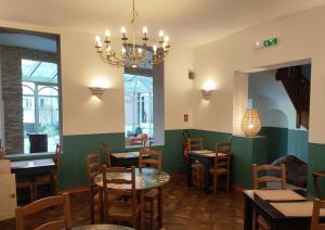 a dining room with tables and chairs and a chandelier at Le Royal Hôtel in Saint-Pol-sur-Ternoise