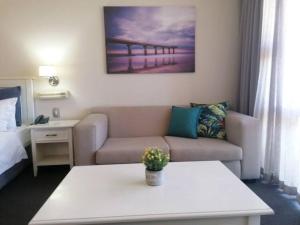 a living room with a couch and a bed at 157 Brookes Hill Suites Near The Beach in Port Elizabeth