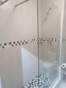 a glass shower with a toilet in a bathroom at 157 Brookes Hill Suites Near The Beach in Port Elizabeth