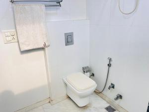 a white bathroom with a toilet and a shower at Hotel Park Pride Pitampura New Delhi, Couple Friendly in New Delhi