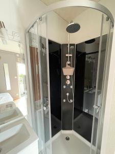 y baño con ducha y puerta de cristal. en Comme une évidence gite et chambres d'hotes, en Saint-Vincent-sur-Jard
