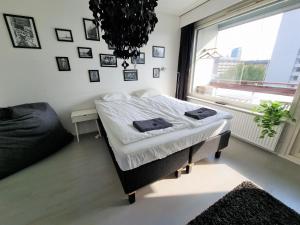 a bedroom with a bed and a large window at Central Gem with Sauna - Big two-room apartment FREE PARKING in Tampere