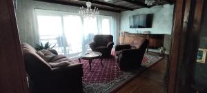 a living room with chairs and a table and a chandelier at Zelený pokoj in Mohelnice