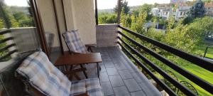 a porch with two chairs and a couch on a balcony at Zelený pokoj in Mohelnice