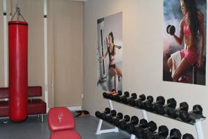 a gym with a poster of a woman lifting weights at PM Services Flora Apartments in Borovets