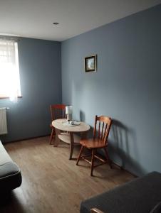 ein Wohnzimmer mit einem Tisch und 2 Stühlen in der Unterkunft Pokoje gościnne u Steni in Kudowa-Zdrój