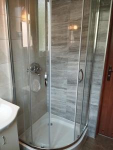 um chuveiro com uma porta de vidro na casa de banho em Pokoje gościnne u Steni em Kudowa-Zdrój