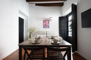comedor con mesa de madera y sillas en numa I Alegre Apartments, en Sevilla