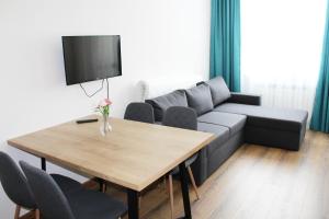 ein Wohnzimmer mit einem Sofa und einem Tisch in der Unterkunft PM Services Borovets Garden Apartments in Borowez