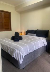 a bedroom with a large white bed with a black headboard at Cosy City Apartment in Melbourne