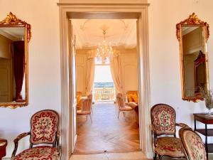 a living room with chairs and a mirror at Chateau la Bainerie in Tiercé