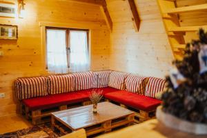 a living room with a red couch in a cabin at Ranč Crna stina in Livno