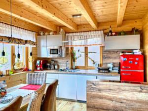 uma cozinha com uma mesa e um frigorífico vermelho em Bad Sankt Leonhard em Klippitztorl