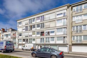 un edificio de apartamentos con coches estacionados frente a él en EVA-Modern 2 bedroom apartment seaside Oostende en Ostende