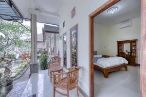 1 dormitorio con 1 cama, mesa y sillas en Yuda Homestay en Nusa Penida