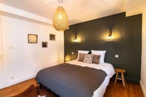 a bedroom with a bed and a black wall at Bleu des Vosges in Gérardmer