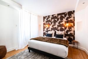 a bedroom with a large bed with a camouflageued wall at Bleu des Vosges in Gérardmer