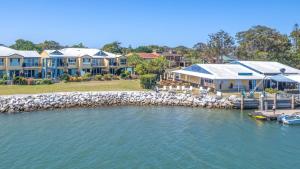 a row of houses on the water next to a dock at Riverview Apartment 1 Block 1 in Iluka