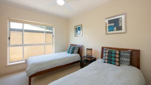 a bedroom with two beds and a window at Riverview Apartment 1 Block 1 in Iluka