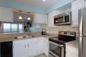 a kitchen with white cabinets and a stainless steel appliances at Sand Castle in Kure Beach