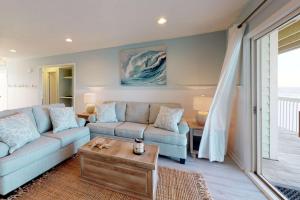 a living room with a couch and a table at Sand Castle in Kure Beach